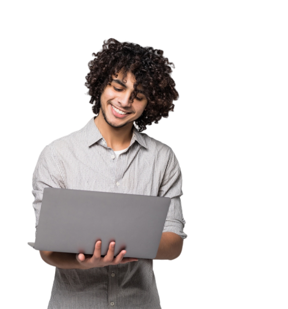 A imagem mostra um homem jovem branco de cabelo escuro e cacheado, sorrindo enquanto segura um notebook e olha para a tela.